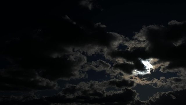 Mysterious image of full moon at night with clouds.