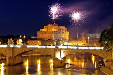 Fireworks shot from Castel St. Angelo explode over the bridge Ponte Vittorio Emanuele II and the...