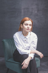Red-haired girl on a dark background shows different emotions