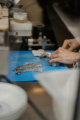 Cooking large shrimp in the kitchen. Hands carve seafood.