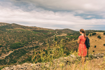 Young girl tourist admiring landscape of Cap de Creus, National Park on the Costa Brava, Spain