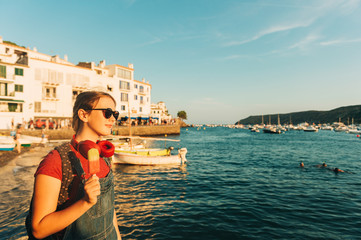 Fototapeta na wymiar Close up portrait of happy teenage girl posing by the sea, wearing backpack and sunglasses