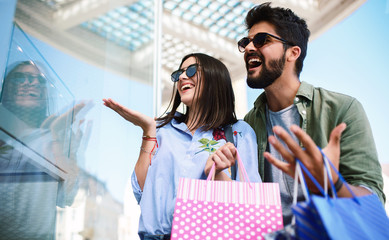 Young couple in shopping looking for presents. Consumerism, love, dating, lifestyle concept