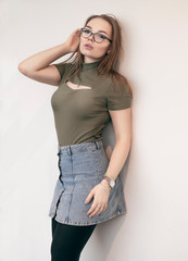 beautiful white girl stands with her back to the wall