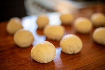 Dough in balls on a kitchen bench ready to cook 