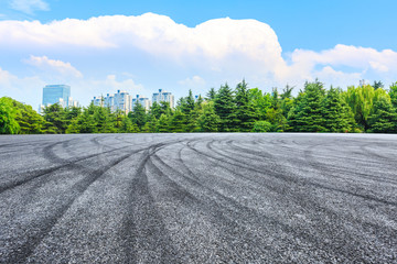 Fototapeta premium Empty asphalt road and green forest under blue sky.
