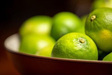 Fresh green limes in bowl 