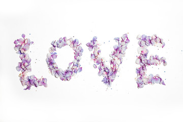 Love written in pink and purple flower petals
