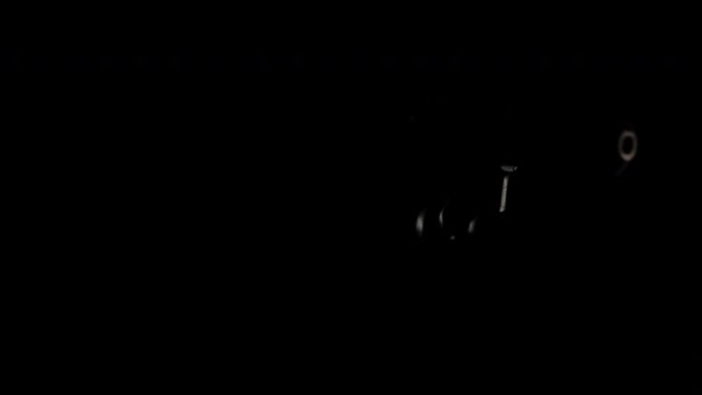 .357 Magnum handgun floats and rotates in darkness with white light flashes.  Shot in 4K.  No people.