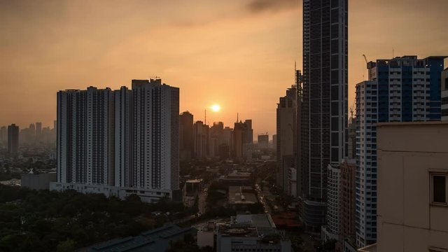 Fiery cityscape sunrise over morning traffic along Gil Puyat, Makati City, Philippines