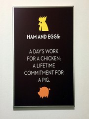 A amusing sign stating that "Ham and eggs is a days work for a chicken, a lifetime commitment for a pig".
