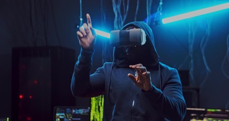 African American man in VR glasses scrolling and tapping in the air with her hands while having VR headset in the dark room with neon lights, wires and computers. Virtual world. - Powered by Adobe