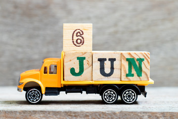 Truck hold letter block in word 6jun on wood background (Concept for date 6 month June)