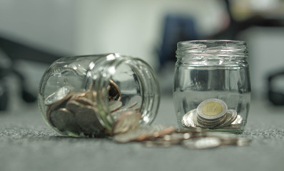Thailand coins ten and five bath in isolate glass jar.
