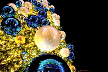 Bauble hanging from a decorated on Christmas tree, copy space.