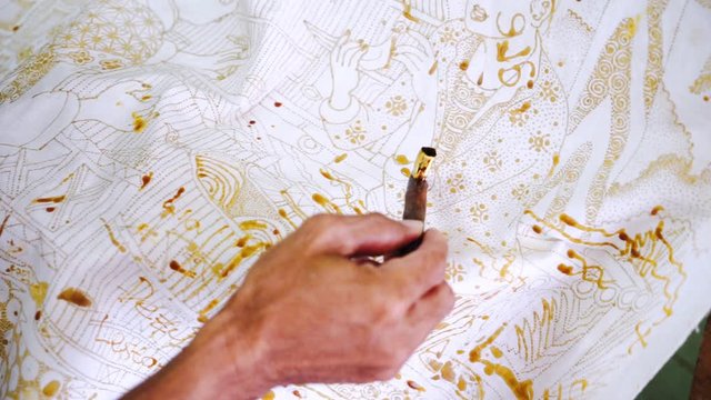 Unknown man hands make batik and using a Canting