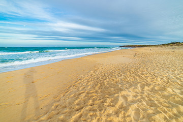 Golden sand beach turquoise blue waving ocean, Vietnam travel destination, Bai Xep Phu Yen province between Da Nang and Nha Trang. Tropical desert beach no people dramatic sky, sunset light.