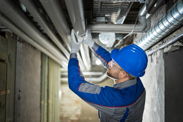 Male Worker Inspecting Pipes