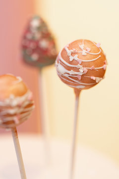 Moderne Cakepops mit Schokolade / Cany Melts &uuml;berzug dekoriert mit Zuckerstreusel Kuchen am Stiel Fondant Dekoration