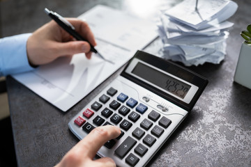 Businessman Calculating Expenses In Office