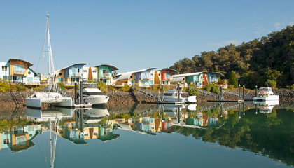 Fototapeta na wymiar Waterfront marina/dock/resort with boats and clear water reflections.