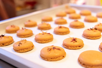 Bunte Macarons mit leckerer Frucht und Knusper Karamell Creme gefüllt Dekoriert mit essbaren Blüten und Glitzerpuder