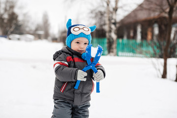 Fototapeta na wymiar happy child boy happily playing in the winter snowballs and smiling