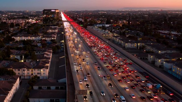 Aerial view of congested urban traffic on a Los Angeles I-405 freeway with headlights and tail lights at night or twilight.