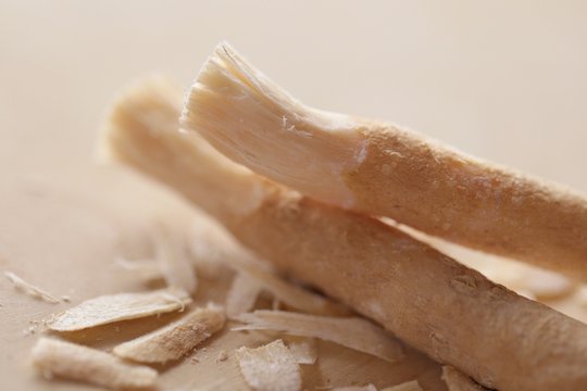 Miswak plant.  Vegetable toothbrush. Dental hygiene. Medicinal plants.Miswak sticks peeled on a wooden  board of beige color on a blurry light background.
