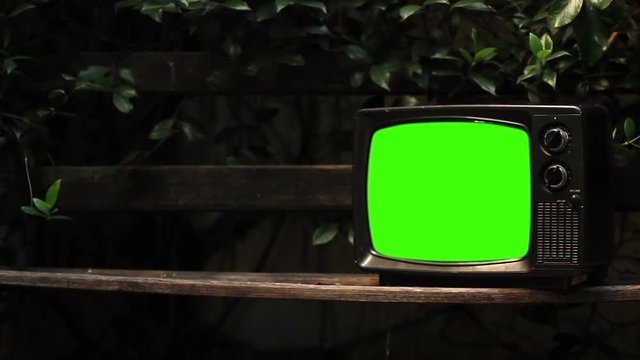 Old 70s TV Green Screen over a Wood Bench Outdoor in the Park. Zoom In. You can replace green screen with the footage or picture you want. You can do it with “Keying” effect in After Effects.
