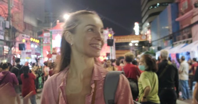 Backpacker tourist foreign women dance on Yaowarat China town Street night market laughing and smiling, Happy women travel in Bangkok Thailand