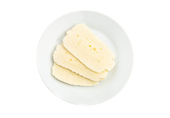 sliced white cheese on a white plate isolated