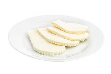 sliced white cheese on a white plate isolated