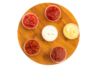 spicy meat seasonings ketchup, adjika, sauce in transparent plastic containers isolated