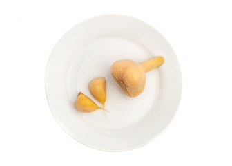 pickled garlic, whole and cloves on a white plate isolated