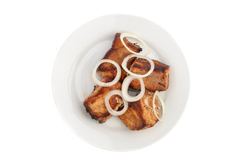 Skewers in large pieces of pork meat with onions on a white plate isolated