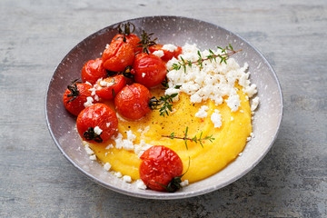 Homemade polenta with grilled cherry tomatoes and ricotta cheese.