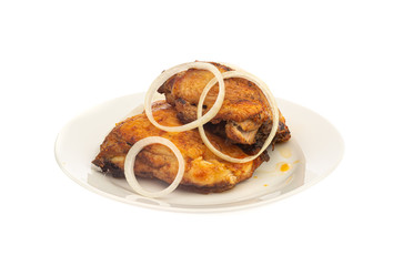 grilled chicken thighs on a white plate with onion isolated