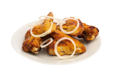 grilled chicken wings on a white plate with onion isolated