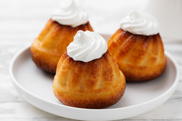 Homemade  dessert rum baba decorated with whipped cream.