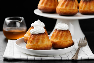 Homemade  dessert rum baba decorated with whipped cream.