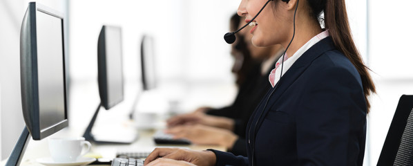 Group of happy smiling business operator customer support team phone services working with headset and computer at call center