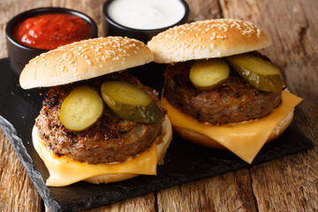 Traditional Oklahoma recipe. Fried onion burgers with cheddar cheese and pickles close-up on a slate board. horizontal
