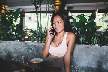 Asian Woman talking on phone at cafe