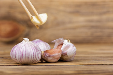 Wooden chopsticks with a clove of garlic.