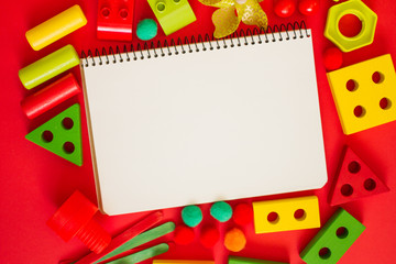 Kids lay Flat. children's toys frame on a red background. Concept of development and education of children. designer, sorter, creativity. the view from the top. Leisure and Hobbies of the child.
