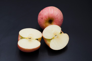 The cut red apple on the black background