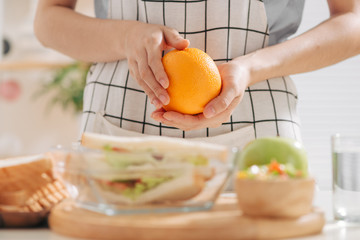 healthy eating, storage, dieting and people concept - close up of woman hands with food in glass container at home kitchen