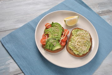 Healthy avocado sandwich , dark bread. Spicy rye toast
