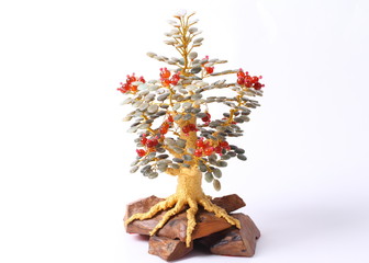 Artificial metal tree with stones on white background